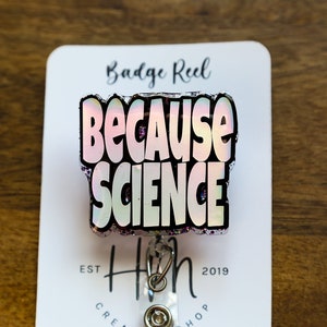 May include: A glittery badge reel with a holographic pink and white "Because Science" design. The reel is attached to a black and silver retractable badge holder.
