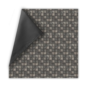 May include: A square, reversible gaming mat with a stone tile pattern on one side and a solid black fabric on the other. The stone tile side features a repeating pattern of gray and off-white squares, creating a textured appearance. The black side is visible where the mat is folded.