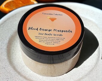 May include: A 2 ounce jar of Blood Orange Margarita body scrub with a black lid and a bright orange label. The label says "Forevershine Collections" and lists the ingredients.