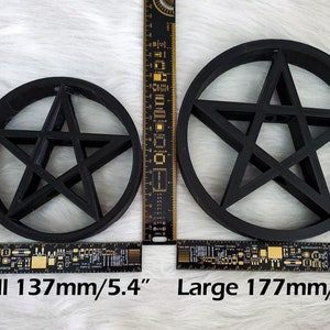 A large and small pentagram tree topper are side by side to show the difference in size with rulers beside and below in both centimetres and inches. The small is 5.4 inches in diameter and the large is 7 inches in diameter.