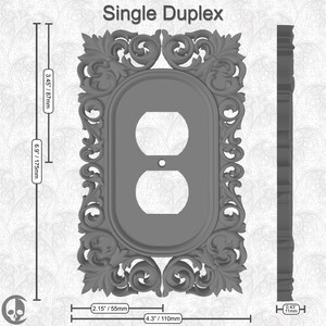 Puede incluir: Una tapa de tomacorriente doble gris con un marco ornamentado y decorativo. La tapa mide 110 mm de ancho y 175 mm de alto.