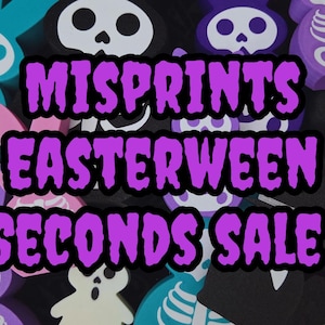 May include: A selection of colourful wooden Easter and Halloween decorations, including bunny and skull shapes. The image displays the text "MISPRINTS EASTERWEEN SECONDS SALE" in a purple and black font.