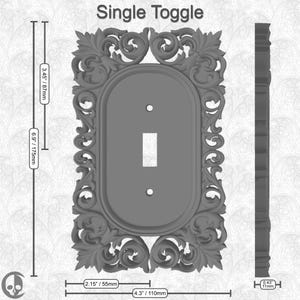 Puede incluir: Una placa de interruptor de palanca simple gris con un marco ornamentado y decorativo. La placa mide 110 mm de ancho por 175 mm de alto. El marco tiene un dise&ntilde;o floral detallado.