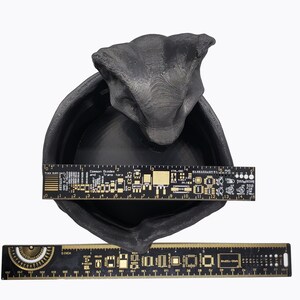 Puede incluir: Taz&oacute;n de cer&aacute;mica negro con una forma org&aacute;nica texturizada que se asemeja a una cabeza de drag&oacute;n. El taz&oacute;n mide aproximadamente 33 cm de ancho.