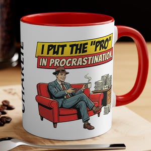 May include: White ceramic mug with a red interior and handle. The mug features a cartoon illustration of a man in a suit relaxing in a red armchair, with the text "I PUT THE 'PRO' IN PROCRASTINATION".