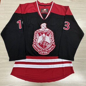 May include: Black and red hockey jersey with a white and red crest featuring a torch and the text "Delta Sigma Theta". The jersey has the numbers "1" and "3" on the sleeves.