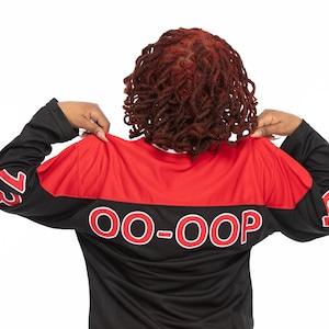 May include: A black and red long-sleeved jersey with the text "OO-OOP" printed in white on the back. The jersey has the numbers "13" and "10" printed on the sleeves.