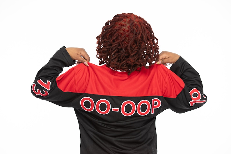 May include: A black and red long-sleeved jersey with the text "OO-OOP" printed in white on the back. The jersey has the numbers "13" and "10" printed on the sleeves.