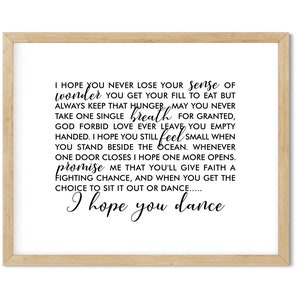 May include: A framed print with a white background and black text. The text reads: 'I hope you never lose your sense of wonder you get your fill to eat but always keep that hunger. May you never take one single breath for granted, God forbid love ever leave you empty handed. I hope you still feel small when you stand beside the ocean. Whenever one door closes I hope one more opens. Promise me that you'll give faith a fighting chance, and when you get the choice to sit it out or dance..... I hope you dance'