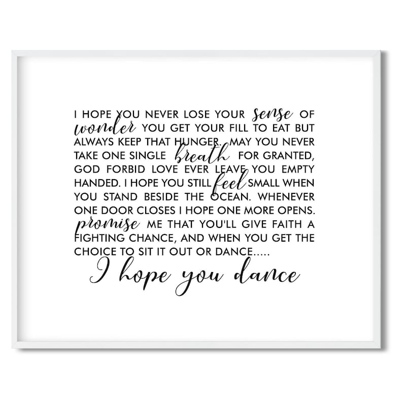 May include: A white framed print with black text that reads: 'I hope you never lose your sense of wonder you get your fill to eat but always keep that hunger. May you never take one single breath for granted, God forbid love ever leave you empty handed. I hope you still feel small when you stand beside the ocean. Whenever one door closes I hope one more opens. promise me that you'll give faith a fighting chance, and when you get the choice to sit it out or dance..... I hope you dance'