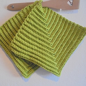 Peut inclure: Deux maniques en crochet vert avec un motif en losange.