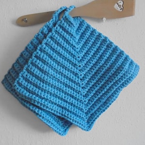 May include: Two blue crocheted pot holders hanging on a wooden spoon.