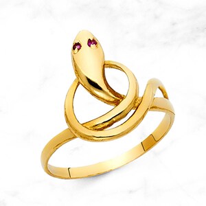 May include: A gold snake ring with two red gemstones for eyes.