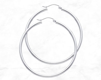 May include: A pair of silver hoop earrings. The hoops are large and circular, with a smooth, polished finish.