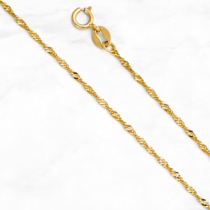 May include: A gold chain necklace with a twisted rope design. The chain is about 18 inches long and has a lobster claw clasp.