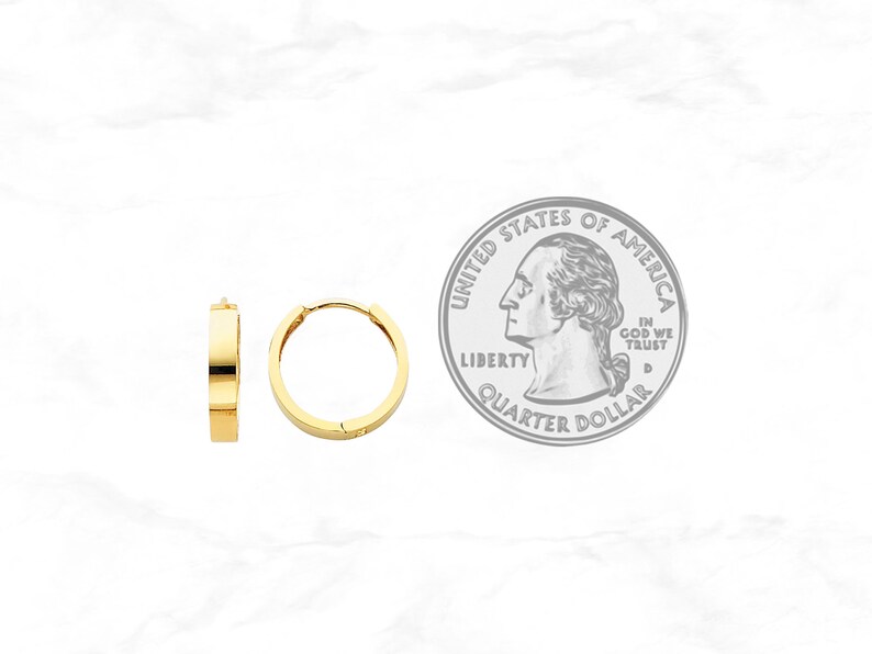 May include: Two gold-colored hoop earrings with a flat, rectangular design. The earrings are shown next to a U.S. quarter for size comparison. The earrings have a simple, modern style and a polished finish.