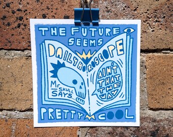 May include: A square print featuring a light blue and cream graphic of an open book titled Daily Horoscope. The text reads The Future Seems Pretty Cool, Mr Skull Says, and Ain't That The Way. A skull illustration is visible on the left page.