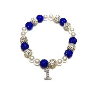 May include: A blue and white beaded bracelet with a silver charm that says "1".