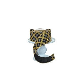 May include: Black and gold plaid ribbon with a silver glitter accent. The ribbon is on a white pedestal.