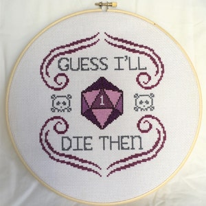 May include: Embroidered hoop art with a purple and pink 20-sided die, two skulls, and the text "Guess I'll Die Then".