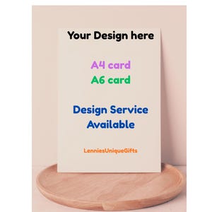 May include: A white card with the text "Your Design here", "A4 card", "A6 card", "Design Service Available", and "LenniesUniqueGifts". The card is on a wooden plate.