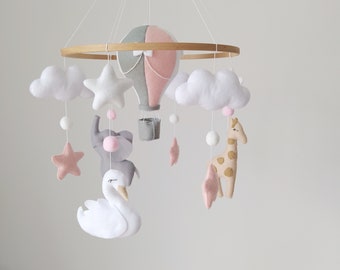 Baby mobile with a balloon elephant, giraffe and swan. Mobile with clouds and stars