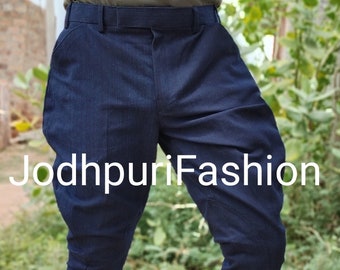 Puede incluir: Un pantalón Jodhpuri azul oscuro con un sutil patrón de rayas finas. El pantalón tiene un ajuste delgado y está diseñado para un look elegante y elegante.