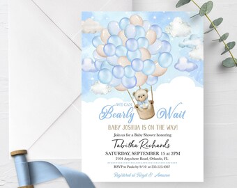 Op de afbeelding: Een babyborrel uitnodiging met een blauw en wit aquarel ontwerp. Een teddybeer houdt ballonnen vast in een luchtballon. De tekst luidt "We can Bearly Wait Baby Joshua is on the way!"  Sluit je aan bij ons voor een babyborrel ter ere van Tabitha Richards Zaterdag 15 september om 14:00 uur 2104 Anywhere Road, Orlando, FL. RSVP aan Paula voor 9/10 op 555.123.4567 Geregistreerd bij Target & Amazon