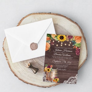 May include: Fall wedding invitation with a rustic wood background, sunflowers, pumpkins, and string lights. The invitation reads "Together with their families Juliana Harrison and Brendon Williams request the pleasure of your company at the celebration of their union Saturday September 27th, 20xx at four o'clock in the afternoon Chatrac Elan Ballroom Hide Anywhere Street Atlanta GA 12545 Reception to follow"