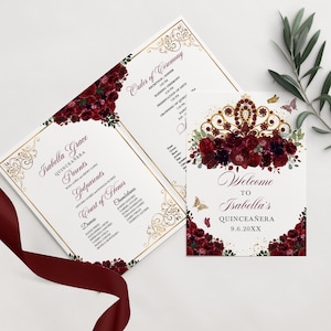 May include: A Quinceañera invitation with a gold and white design. The invitation features a burgundy floral design with a gold crown and butterflies. The text on the invitation reads "Isabella Grace Quinceañera" and "Welcome to Isabella's Quinceañera 9.6.20XX".