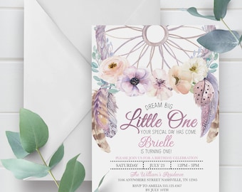 May include: A purple and white invitation with a dreamcatcher design and floral accents. The text reads "Dream Big Little One Your Special Day Has Come Brielle Is Turning One!"  Please join us for a birthday celebration Saturday July 23 12PM-3PM The William's Residence 3106 Anywhere Street Nashville, TN 12345 RSVP to Amelia 555.123.4567 by July 10th.