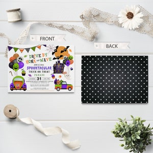 May include: A Halloween-themed invitation with a black and white polka dot background. The front of the invitation features a cartoon illustration of a spooky house, a ghost, and two cars decorated for Halloween. The text on the invitation reads "Drive By Honk and Wave Join Us For A Spooktacular Trick Or Treat Parade October 31".