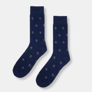 Può includere: Un paio di calzini blu navy con un motivo ripetitivo di fiori di cardo rosa e verdi.