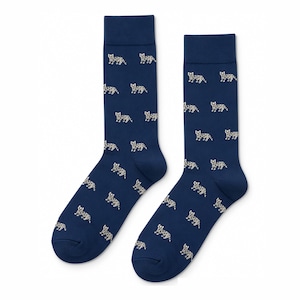May include: A pair of navy blue crew socks featuring a repeating pattern of small, white, leopard-like feline figures. The socks have a solid navy blue ribbed cuff at the top and a consistent dark blue base color throughout the entire garment.