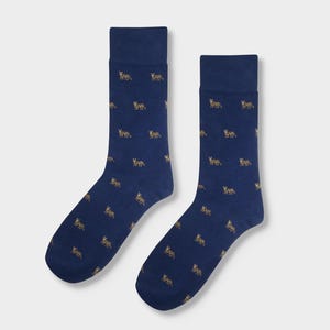 Può includere: Un paio di calzini blu con un motivo ripetuto di piccole figure di animali marroni e beige.