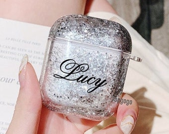 May include: A clear glitter phone case with a silver glitter finish and the name "Lucy" printed in black.