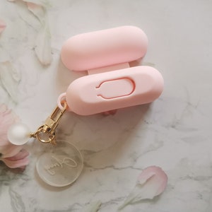 May include: A pink silicone keychain with a small clear charm that says "Jenny". The keychain has a small loop for attaching to a bag or keys.