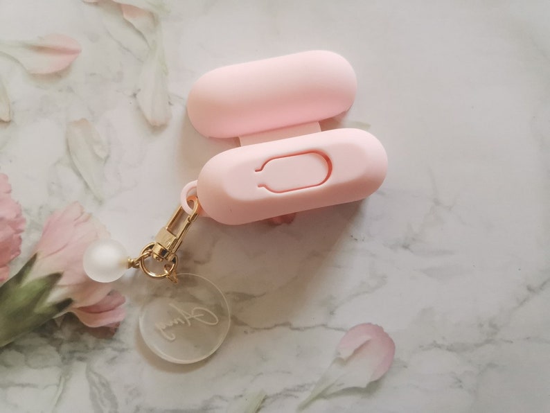 May include: A pink silicone keychain with a small clear charm that says "Jenny". The keychain has a small loop for attaching to a bag or keys.