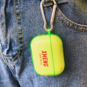 K&ouml;nnte beinhalten: Ein leuchtend gelbes und gr&uuml;nes Etui mit einem silbernen Karabinerhaken. Auf dem Etui steht der Text "XMENG 1995 06 01".