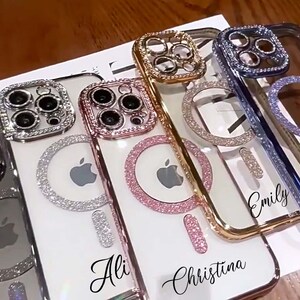 Op de afbeelding: Vier transparante telefoonhoesjes met strass en een ringhouder. De hoesjes zijn versierd met verschillende gekleurde strass en hebben de namen "Ali", "Christina", "Emily" en een vierde hoesje zonder naam.