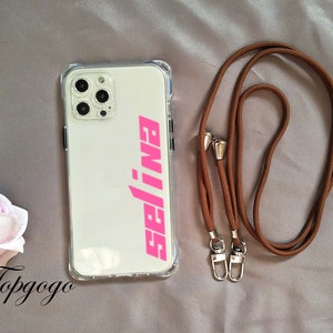 May include: A clear phone case with a pink "99J" logo and a brown phone strap with gold clasps.