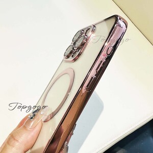 Puede incluir: Una funda para tel&eacute;fono de color rosa dorado con la parte posterior transparente y un soporte para anillo. La funda tiene una protuberancia de c&aacute;mara elevada con un dise&ntilde;o decorativo.