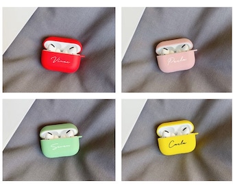 Könnte beinhalten: Vier personalisierte AirPod-Hüllen in verschiedenen Farben: Rot, Rosa, Grün und Gelb. Jede Hülle trägt einen Namen: "Vince", "Peela", "Seven" und "Carla".