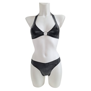 May include: Black rubber bikini top and bottom with a silver ring detail. The top has a halter style strap.
