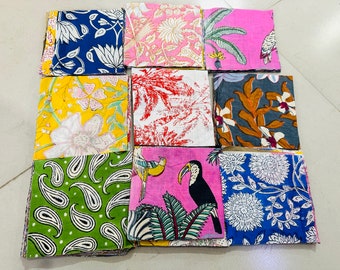 May include: Nine fabric squares with different floral and animal prints. The squares are arranged in a grid pattern. The prints include paisley, toucans, flowers, and leaves. The fabrics are in shades of blue, green, pink, yellow, and red.