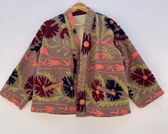 Könnte beinhalten: Eine braune Jacke mit einem floralen Stickmuster in den Farben Rosa, Rot, Grün und Blau. Die Jacke hat einen Knopfverschluss und zwei Taschen.