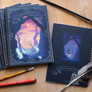 Peut inclure: Une pile de cinq carnets à spirales avec des couvertures bleu foncé et des illustrations d'une scène de forêt avec une lune et des étoiles. Les carnets portent le texte "Cave Your Prayer List Here" sur la couverture.
