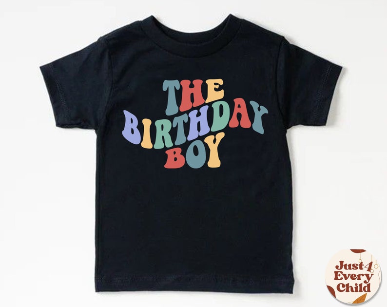K&ouml;nnte beinhalten: Schwarzes T-Shirt mit dem Text "The Birthday Boy" in Regenbogenfarben.