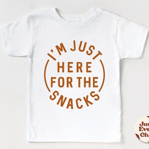 May include: White baby onesie with a brown circle graphic that says "I'm Just Here For The Snacks".