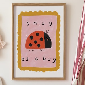 Könnte beinhalten: Ein gerahmter Kunstdruck mit einer Cartoon-Marienkäfer-Illustration und dem Text "snug as a bug". Der Druck befindet sich in einem Raum mit einer rosa Kommode, einem Stoffhasen und einer Kerze. Ein Himmelbett mit rot-weißen Streifen ist sichtbar.